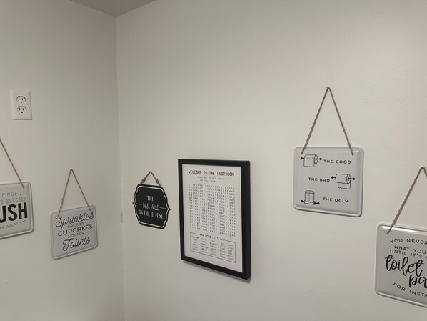 A wall with various signs and a framed word list.
