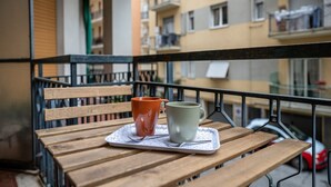 A wooden table with two cups on a tray, a bench, and a balcony railing. - 🏠 PROPERTY DESCRIPTIONCasa Simona is a modern and renovated apartment, located in a quiet area just a few minutes' walk from the center of Rapallo. With shops, restaurants, and public transport nearby, it’s the ideal starting point to explore the Gu (Rapallo)