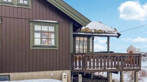 A wooden house with a balcony and a snow-covered roof.