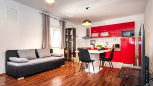 Un espacio habitable pequeño con sofá, comedor y kitchenette.