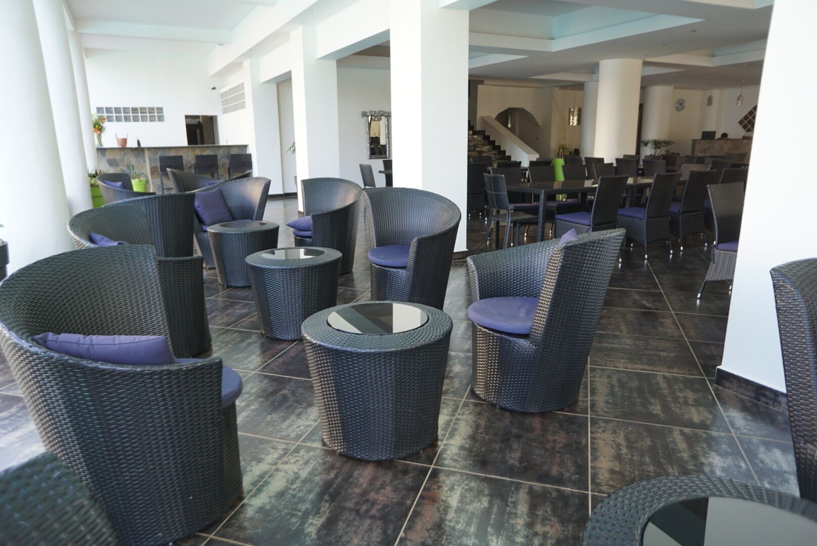 A spacious indoor area with wicker furniture and a tiled floor.
