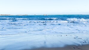 Una platja amb onades i un cel clar.