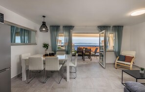 Enjoy a clear view of the sea from this spacious living area with a dining and seating space.