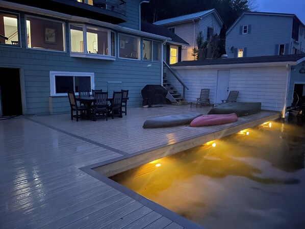 A backyard with a swimming pool, outdoor furniture, and a staircase leading to a second floor.