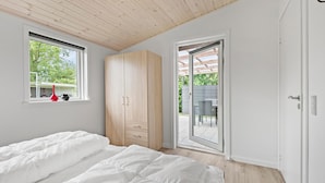 A bedroom with a bed, a wardrobe, and a sliding glass door leading to an outdoor area. - Awesome home in Tarm with WiFi (Tarm)