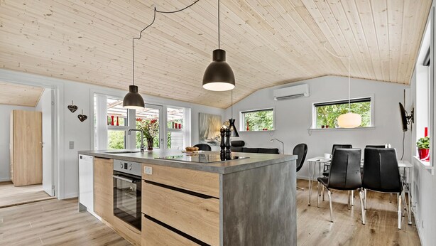 A modern kitchen with a central island, wooden flooring, and pendant lighting. - Awesome home in Tarm with WiFi (Tarm)