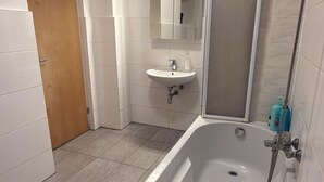 Un baño con bañera, lavamanos y ducha.