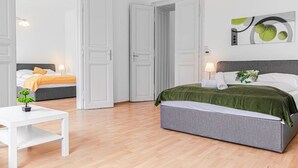 Una habitación de hotel con una cama, una mesita de noche, una pequeña planta y un cuadro en la pared.