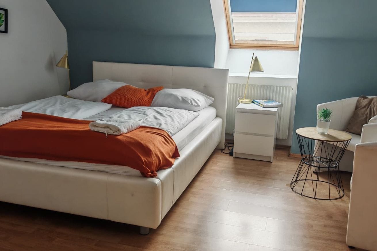 Ein Schlafzimmer mit einem Bett, einem Nachttisch, einem runden Tisch und einem Fenster.