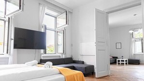 Ein Hotelzimmer mit Bett, einer Couch, einem Fernseher und einer Whiteboard-Tafel.