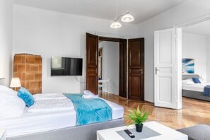 Une chambre d’hôtel moderne, équipée d’un lit, d’une télévision, d’une plante et d’un canapé.