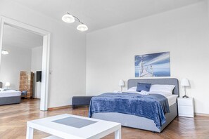 Une chambre à coucher moderne avec un lit, des tables de chevet, un tableau et un miroir.