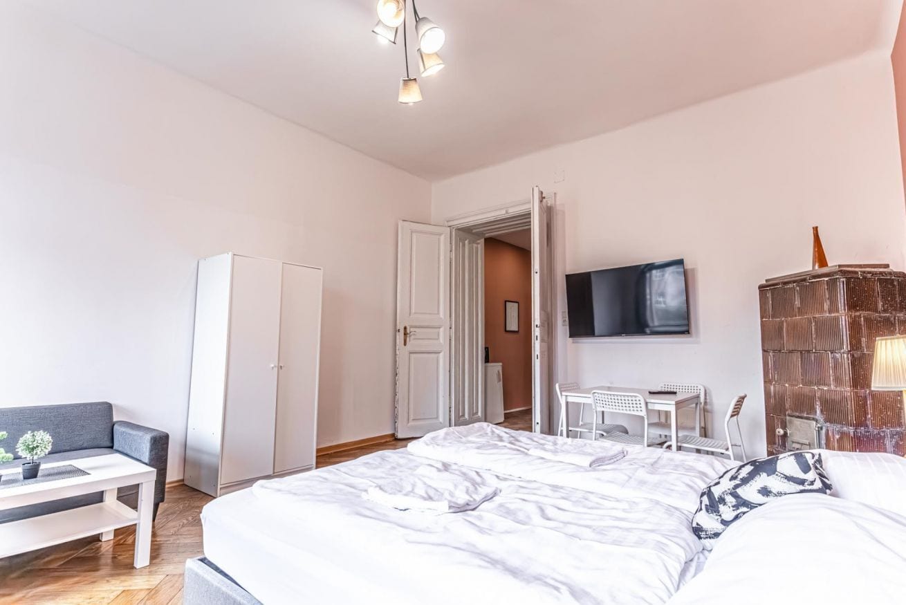 Een slaapkamer met een bed, een bureau, een stoel, een kledingkast en een televisie.