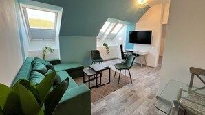 Ein modernes Wohnzimmer mit einer Couch, einem Couchtisch und einem Fernseher.