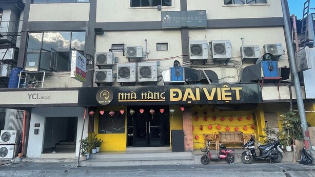 A multi-story building with a billiard hall on the ground floor, air conditioning units, and a motorcycle parked outside.