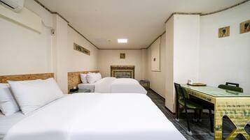Una habitación de hotel con dos camas, un escritorio pequeño y una silla.