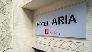 Schild für Hotel Aria mit Parkplatzsymbol.