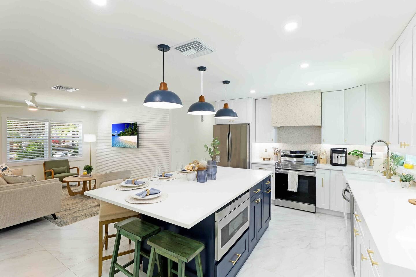 A modern kitchen with a central island, stainless steel appliances, and pendant lighting.
