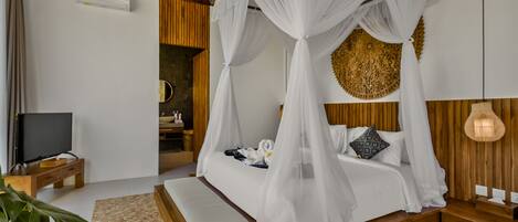 A modern bedroom with a four-poster bed, a television on a wooden nightstand, and a large plant in the corner.