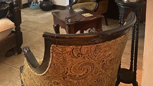 A traditional living room with ornate furniture, a wooden door, and a mirror. - The Belair SeaSide Villas. 4 suites, 2 guests per Suite. 1, 2/bedroom/3 guests (Belmont)