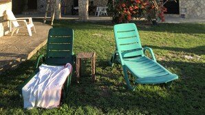A stone building with arched windows and a thatched roof structure. - The Belair SeaSide Villas. 4 suites, 2 guests per Suite. 1, 2/bedroom/3 guests (Belmont)