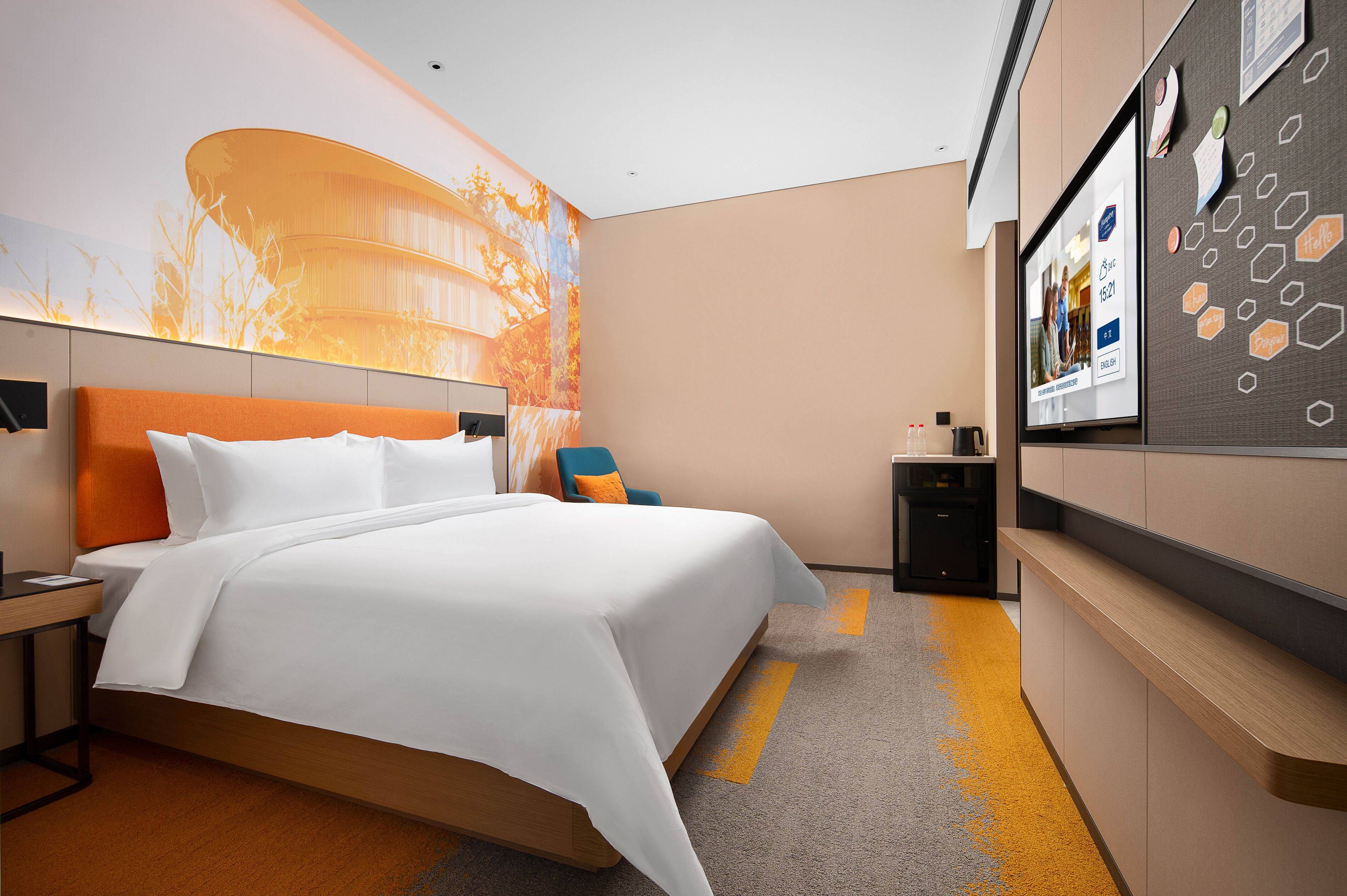 A modern hotel room with a large bed, a desk, and a TV.