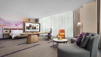Une chambre d’hôtel comprenant un lit, un bureau, une télévision, un canapé et une chaise.