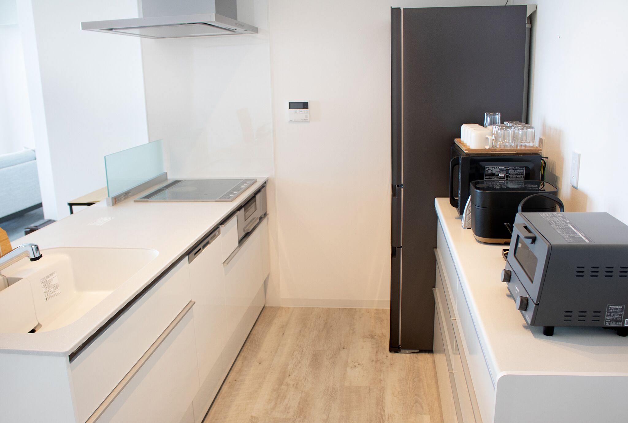A modern kitchen with a stainless steel refrigerator, a coffee machine, and a toaster.