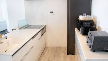 A modern kitchen with a stainless steel refrigerator, a coffee machine, and a toaster.