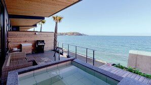 A modern outdoor pool area with a wooden deck, a grill, and a view of the sea. - Solavilla Umi Terrace Minamiawaji (Minamiawaji)