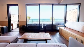 A modern hotel room with a large balcony, a bed, a seating area, and a view of the sea. - Solavilla Umi Terrace Minamiawaji (Minamiawaji)