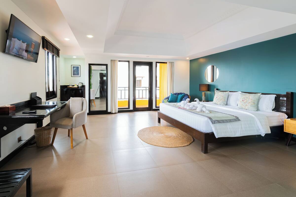 Habitación de hotel con cama, escritorio, silla y vistas a través de la puerta.