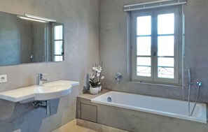 A modern bathroom with a white sink, a bathtub, and a window with a view. - La Bastide D'Eygalieres (Eygalieres)