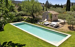 A rectangular swimming pool with a tiled deck, surrounded by a well-maintained lawn and various trees. - La Bastide D'Eygalieres (Eygalieres)