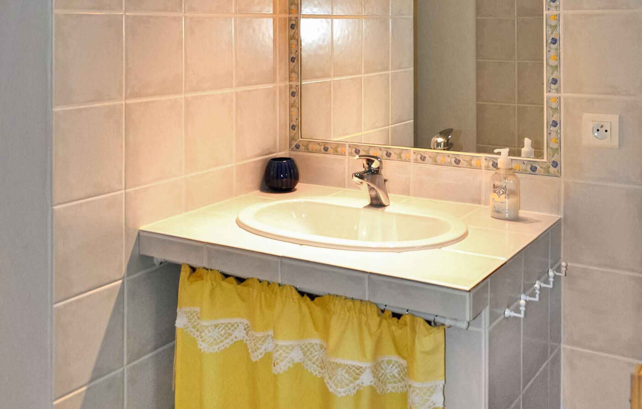 A bathroom with a sink, mirror, and yellow towel.