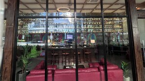 A bar with a glass front, red seating, and a sign reading 'LUX Lounge and Bar'.