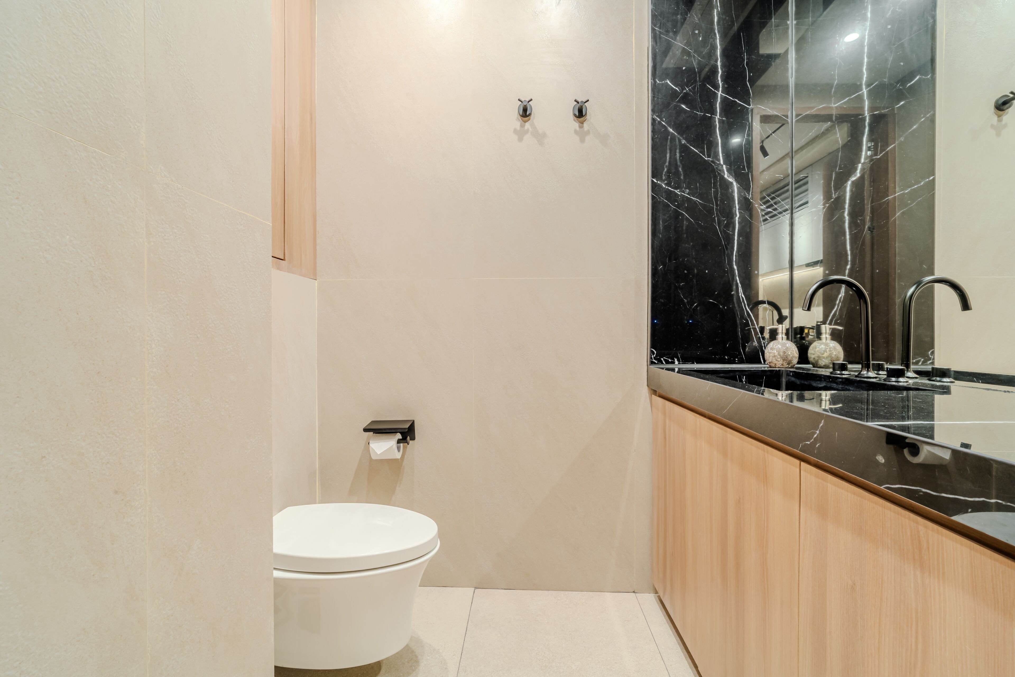 A modern bathroom with a toilet, sink, and mirror.
