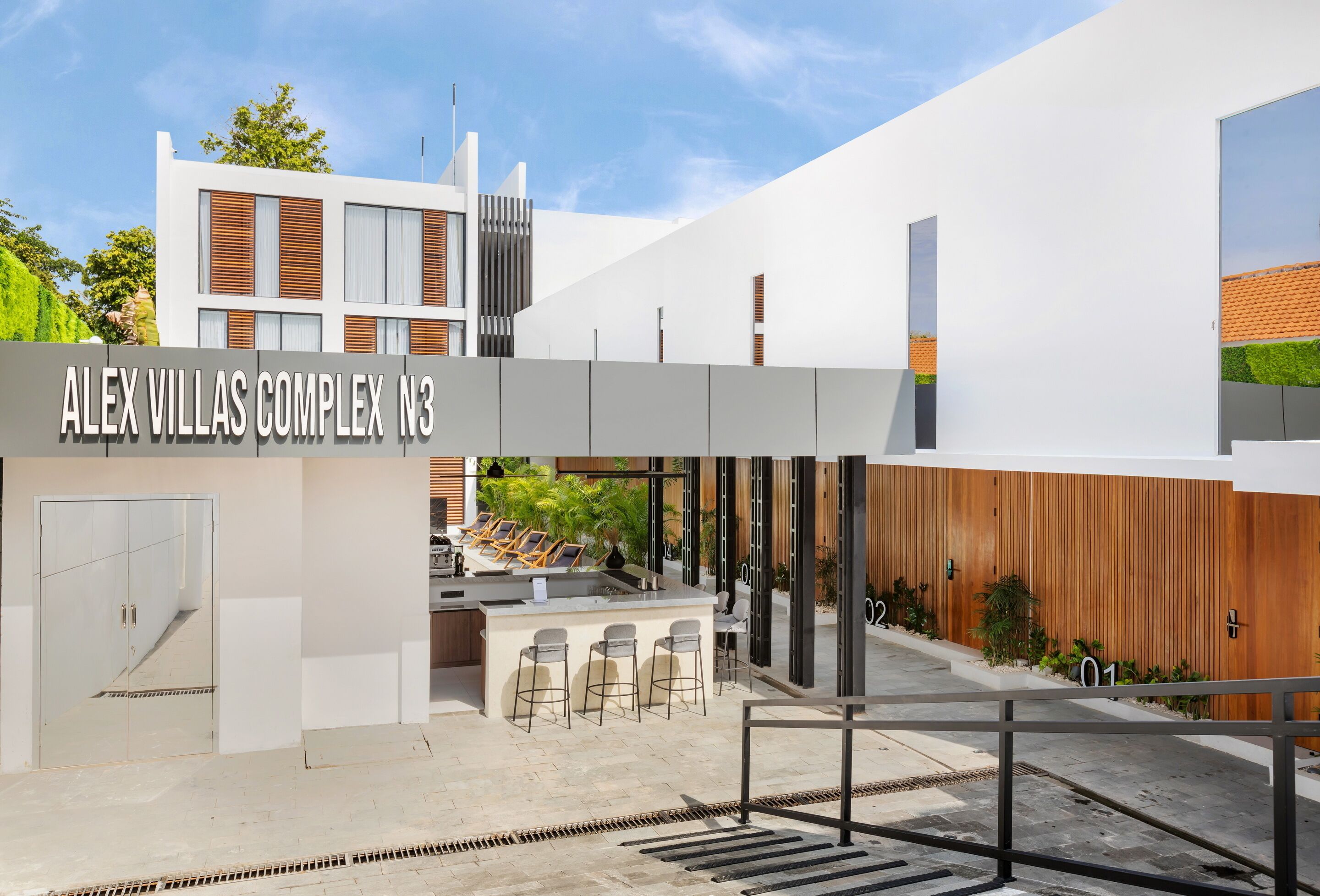 Un bâtiment moderne sur lequel on peut lire l’inscription suivante : « ALEX VILLAS COMPLEX N3 ».