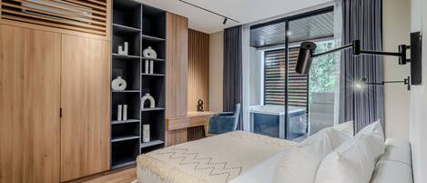 A modern bedroom with a bed, a desk, and a wardrobe.