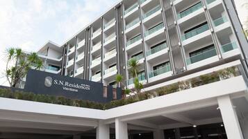 Un moderno edificio de hotel con varios balcones y un cartel que indica que es S.N. Residences Vientiane.
