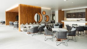 A modern hotel lobby with a seating area, wooden paneling, and a bar. - SN Residences (Vientiane)