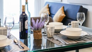 A dining table set with plates, glasses, and cutlery, a bottle of wine, and a vase with flowers. - Penang Straits Garden Georgetown (George Town)