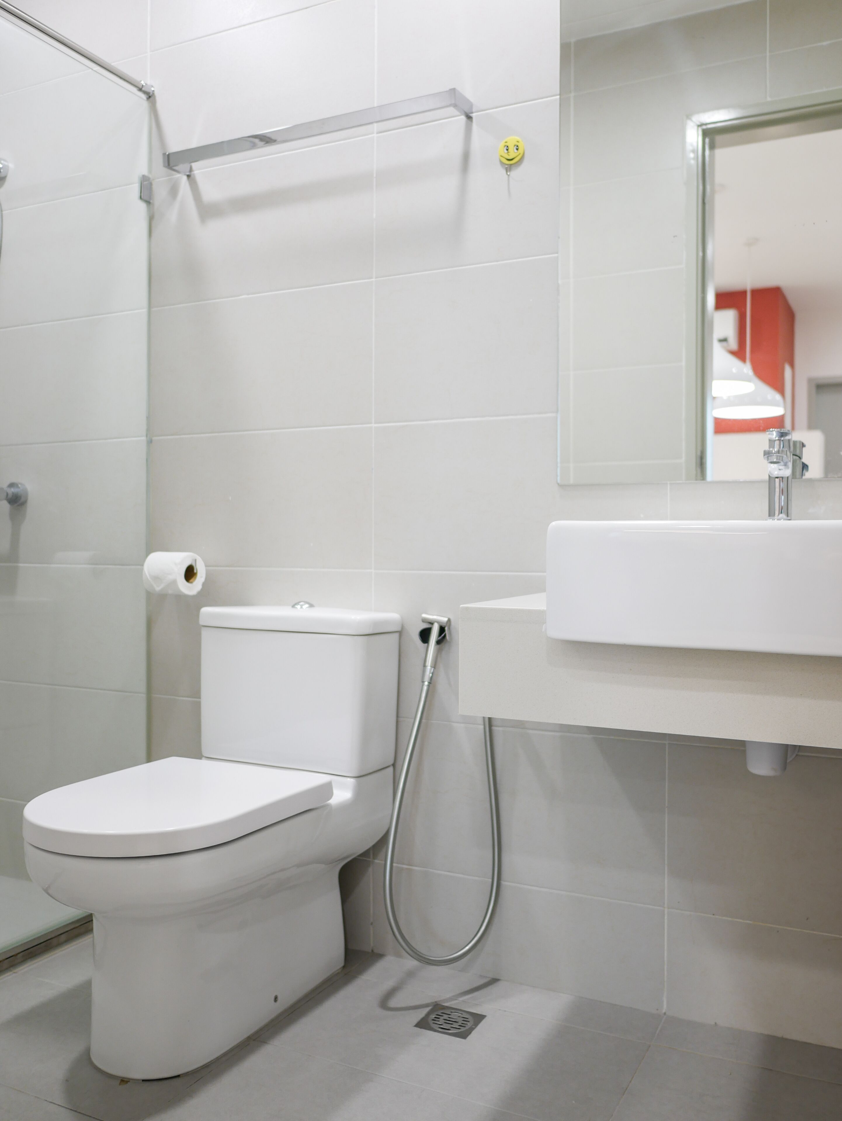 Une salle de bain moderne équipée de toilettes, d’une douche et d’un lavabo.