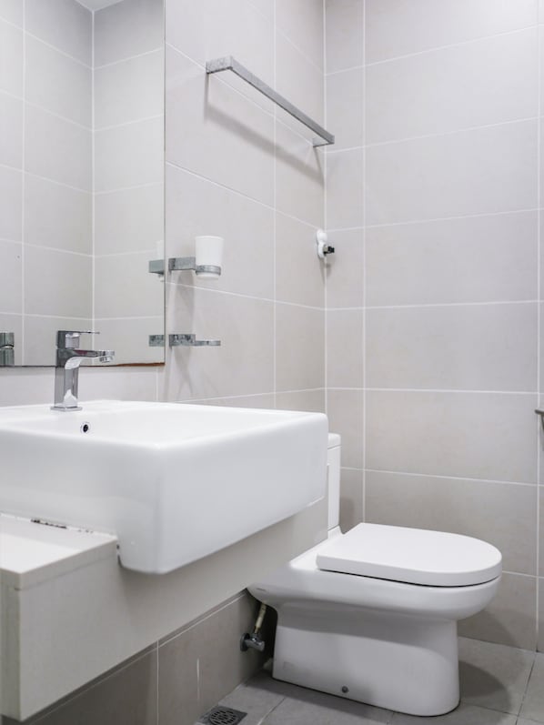 A modern bathroom with a white sink, a toilet, and a mirror. - Penang Straits Garden Georgetown (George Town)