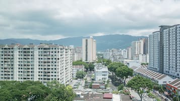 Un edificio residencial de gran altura con varios pisos y balcones, rodeado de otros edificios y vegetación.