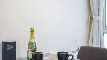 A dining table set with a bottle of champagne, a book, and various dishes and glasses.