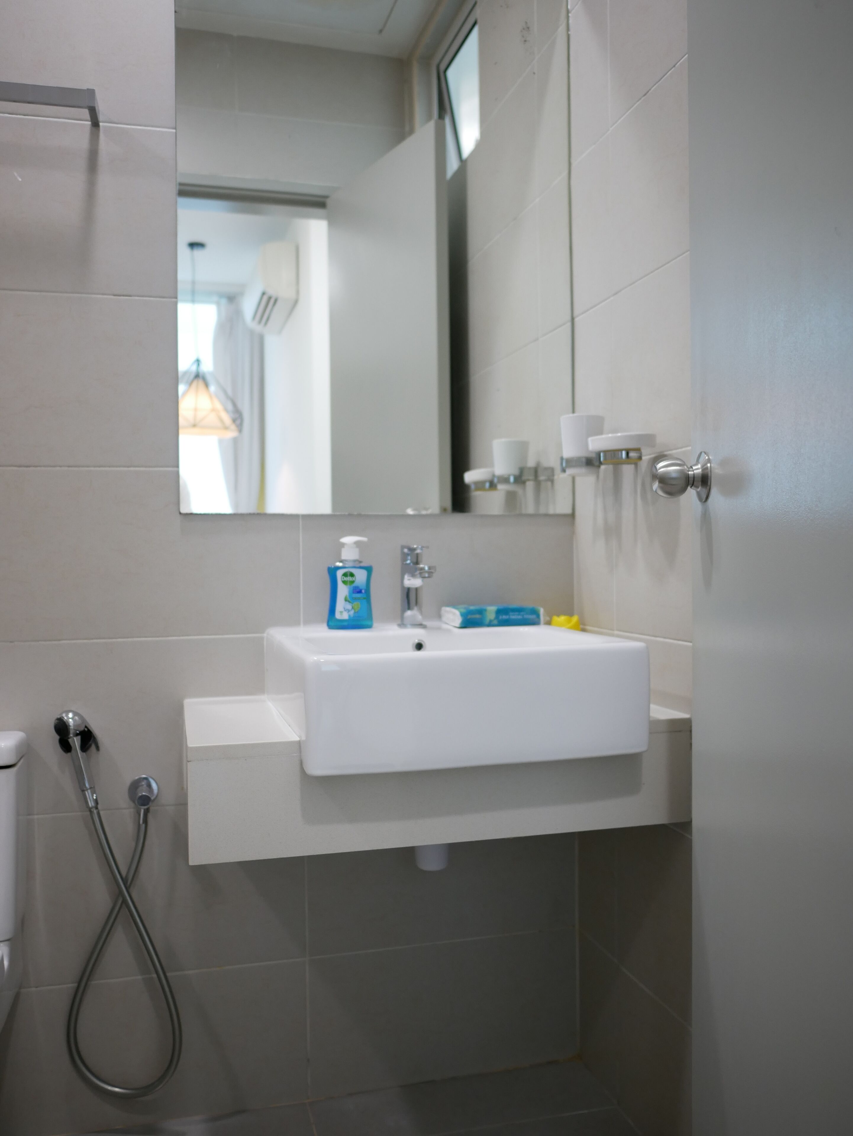 A bathroom with a white sink, a mirror, and a shower.
