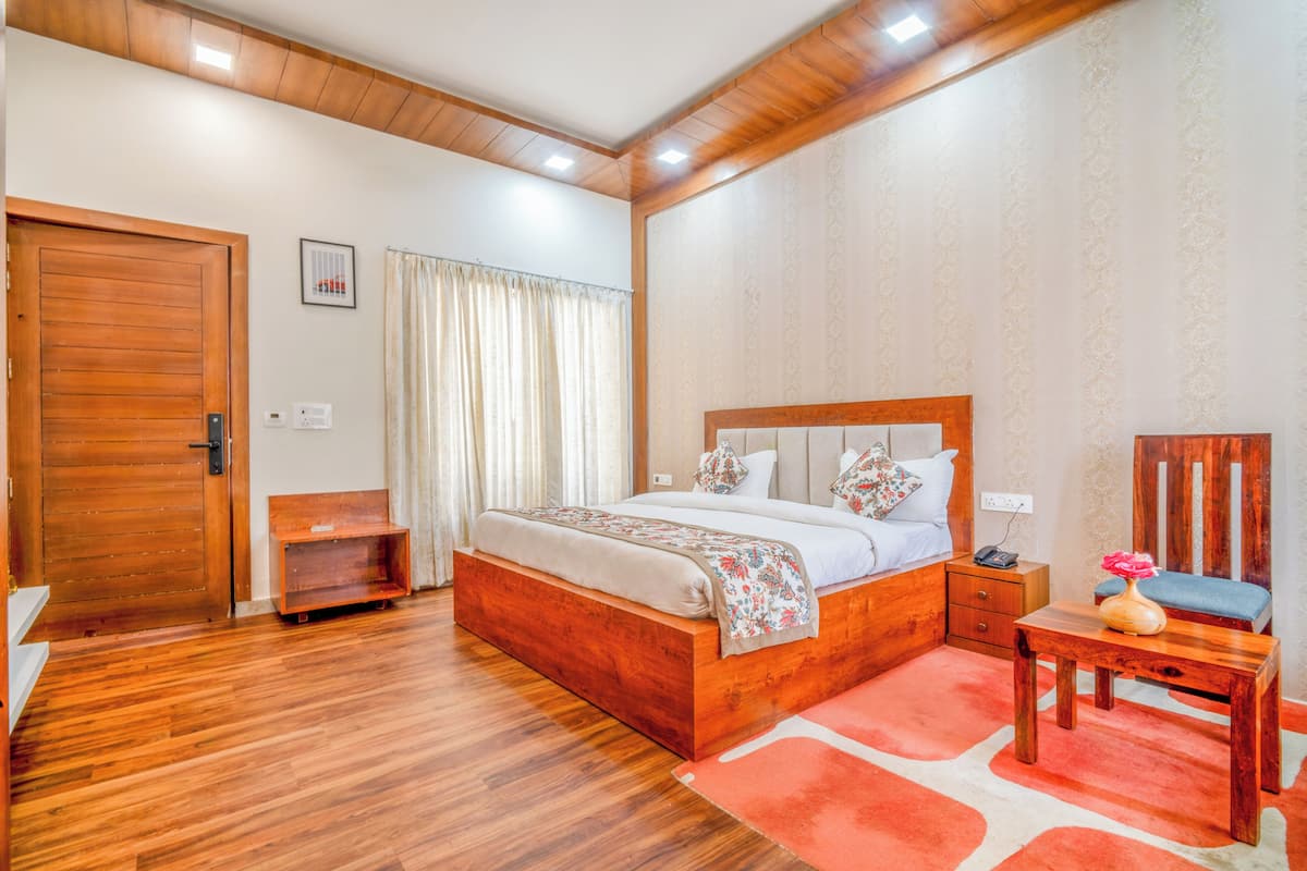 A bedroom with a wooden bed, a nightstand, a chair, and a desk.