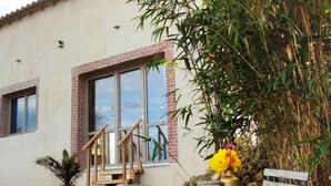 Un edificio con fachada de ladrillo, ventanas amplias y una escalera que lleva a un balcón.