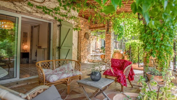 An outdoor patio with wicker furniture, stone walls, and potted plants. - Charming stone house with airco and a large pool (Lorgues)